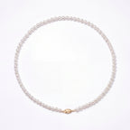 Pearl necklace with a gold clasp on a white background