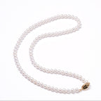 Pearl necklace with a gold clasp on a white background